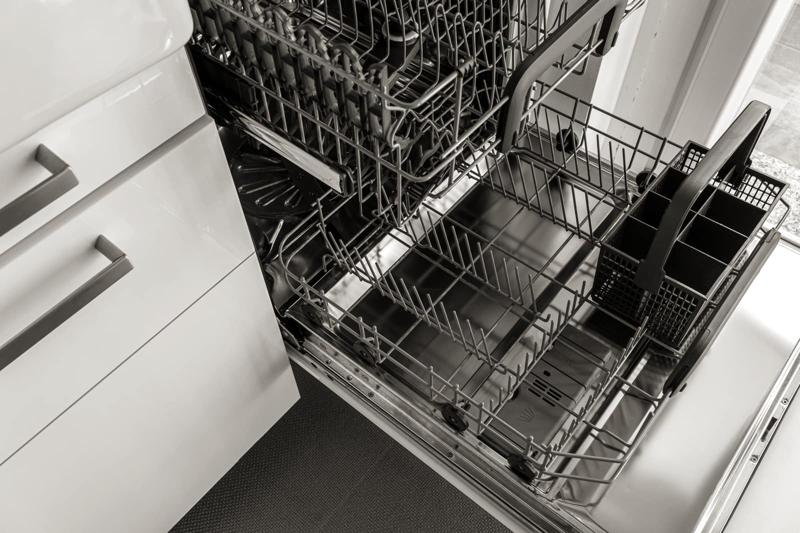 An open dishwasher in a clean kitchen