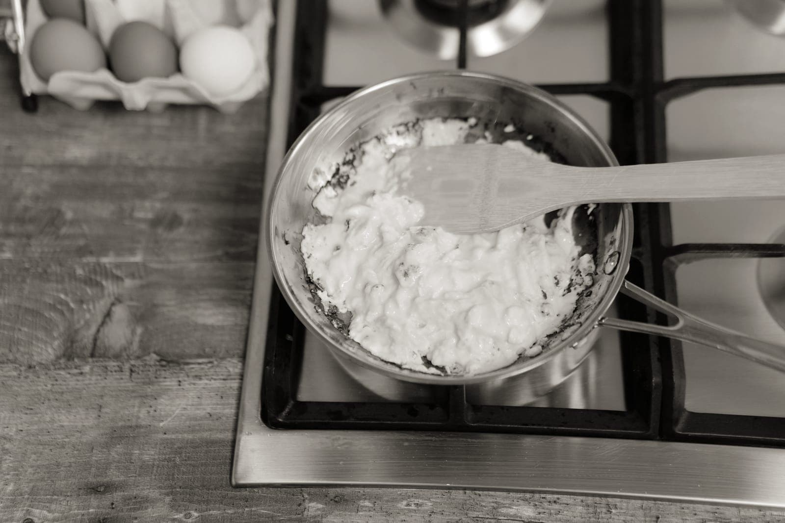 Eggs cooking in a dark steel pan