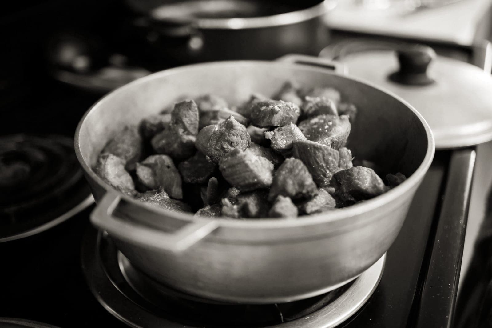 A heavy lidded pot of stew on a stovetop