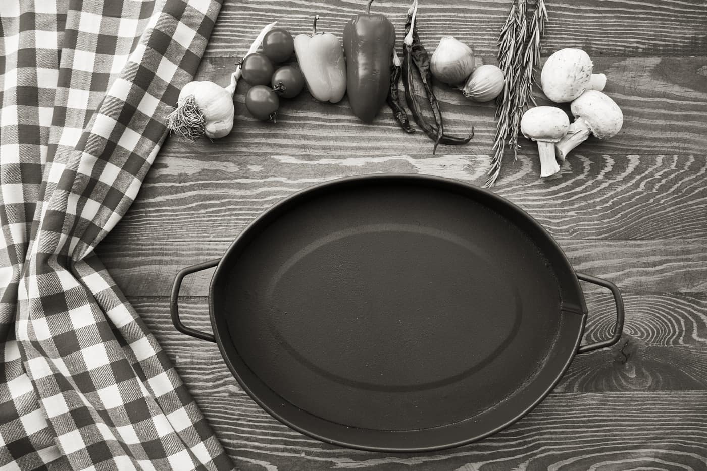 A carbon steel pan and a cast iron skillet on a table