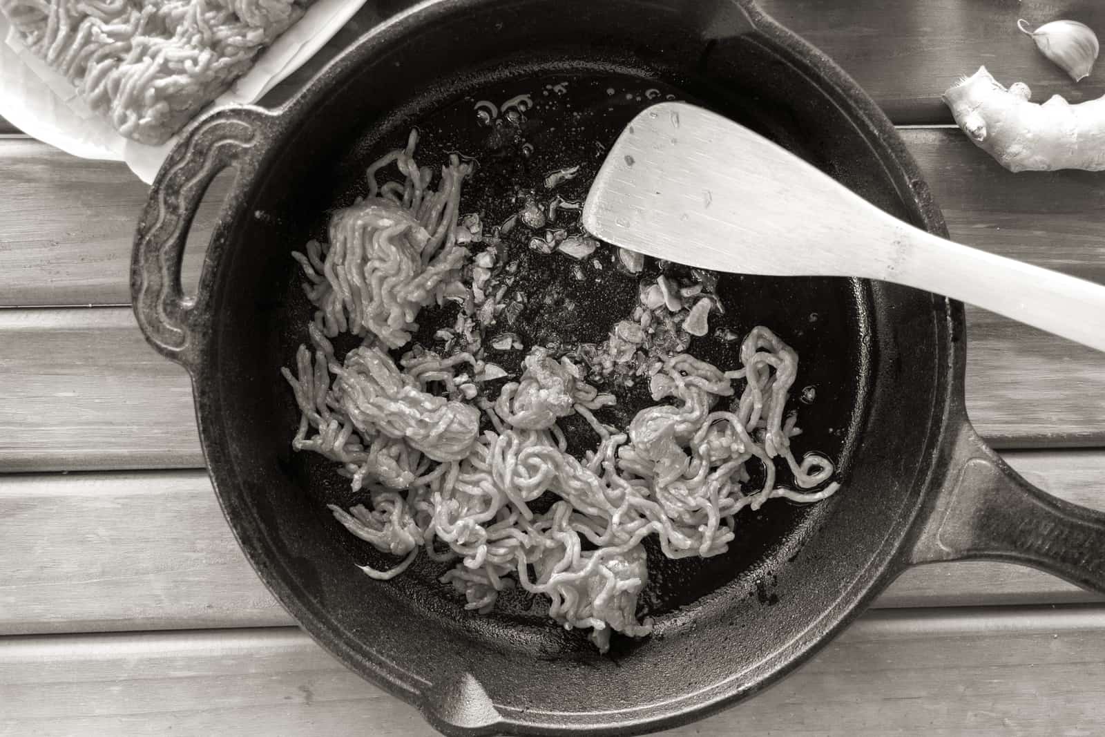 A cast iron skillet beside a coated frying pan