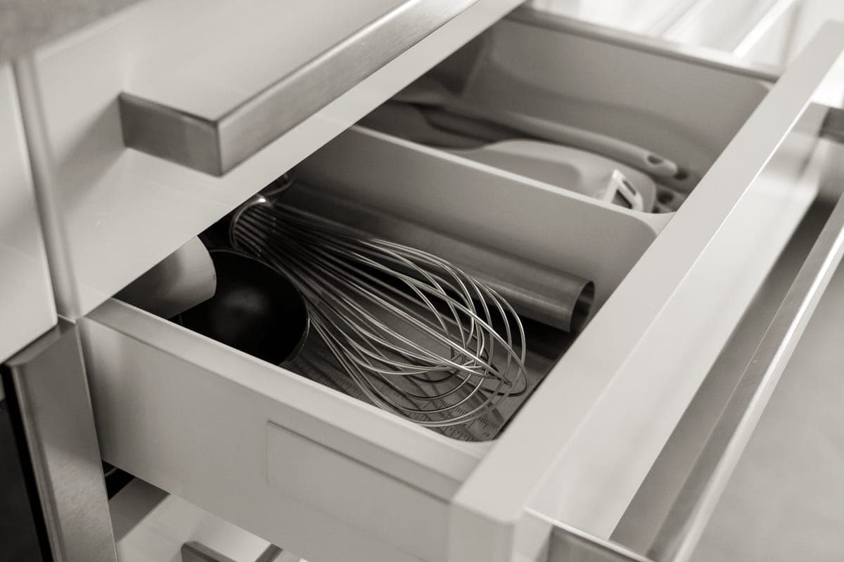 A kitchen drawer holding assorted cooking utensils