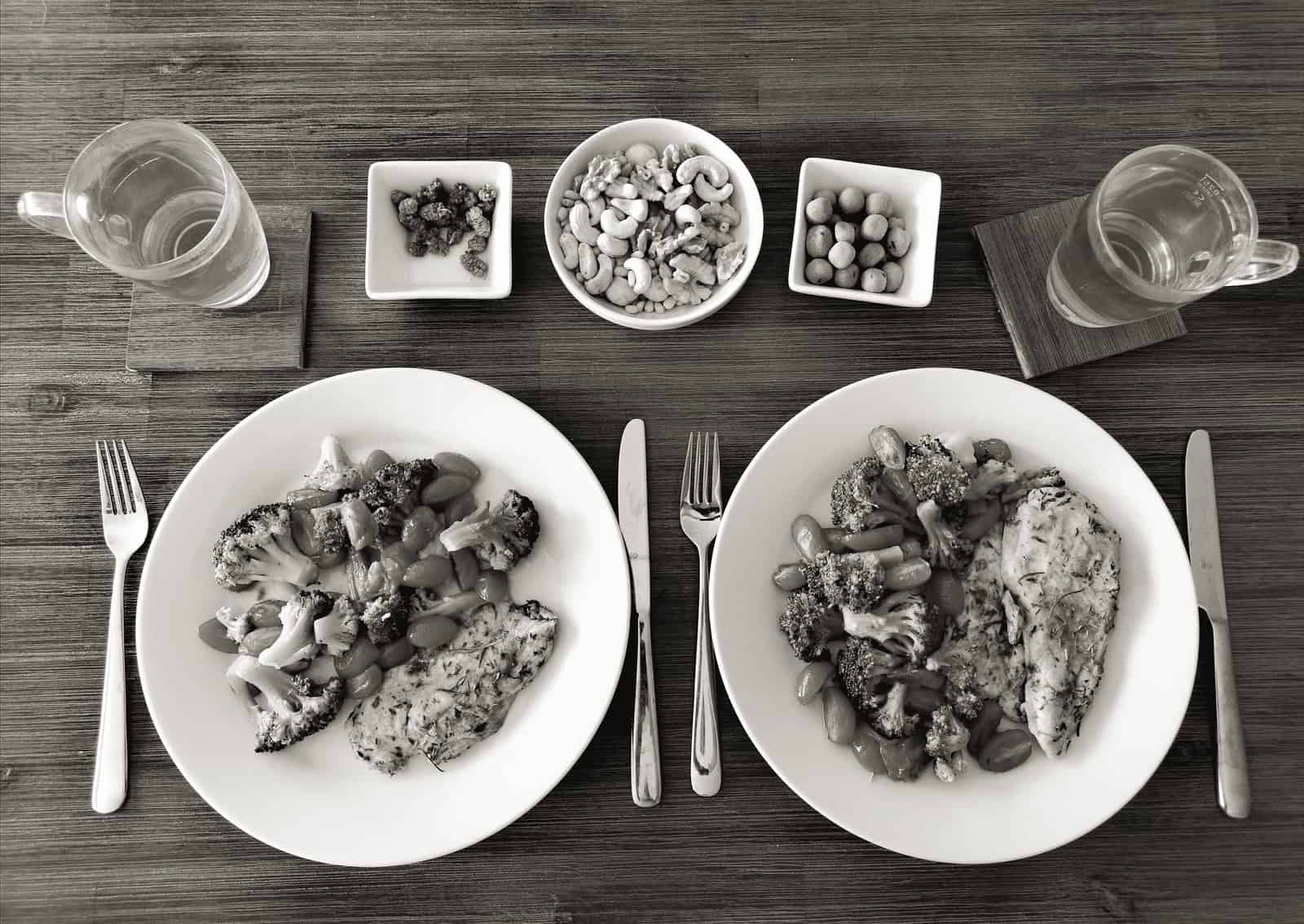 Two plates of food beside a skillet on a stove