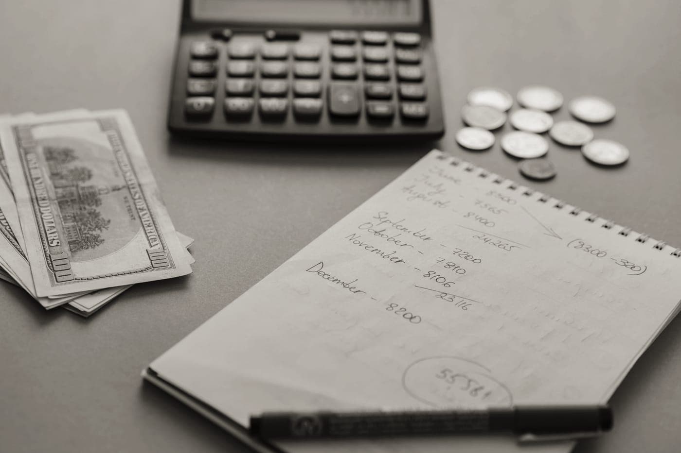 A notebook and pen beside cookware on a kitchen counter
