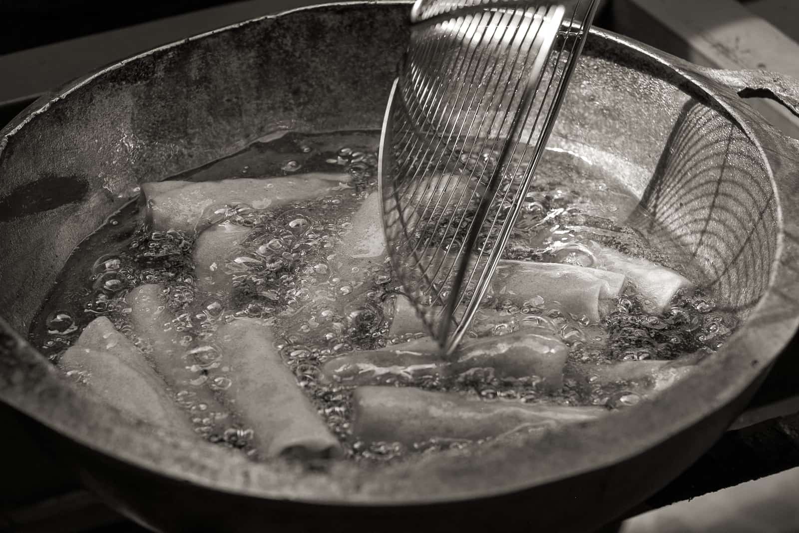 Food being fried in a pot of hot oil