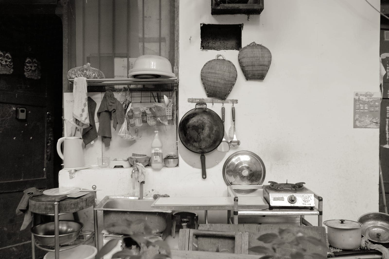 A cluttered kitchen cupboard full of pans
