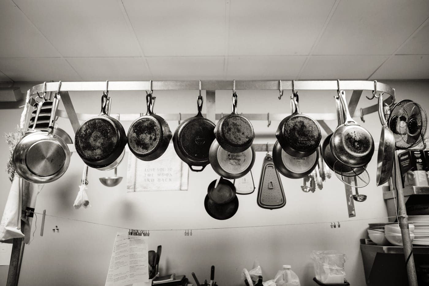 Two frying pans hanging from a kitchen rail