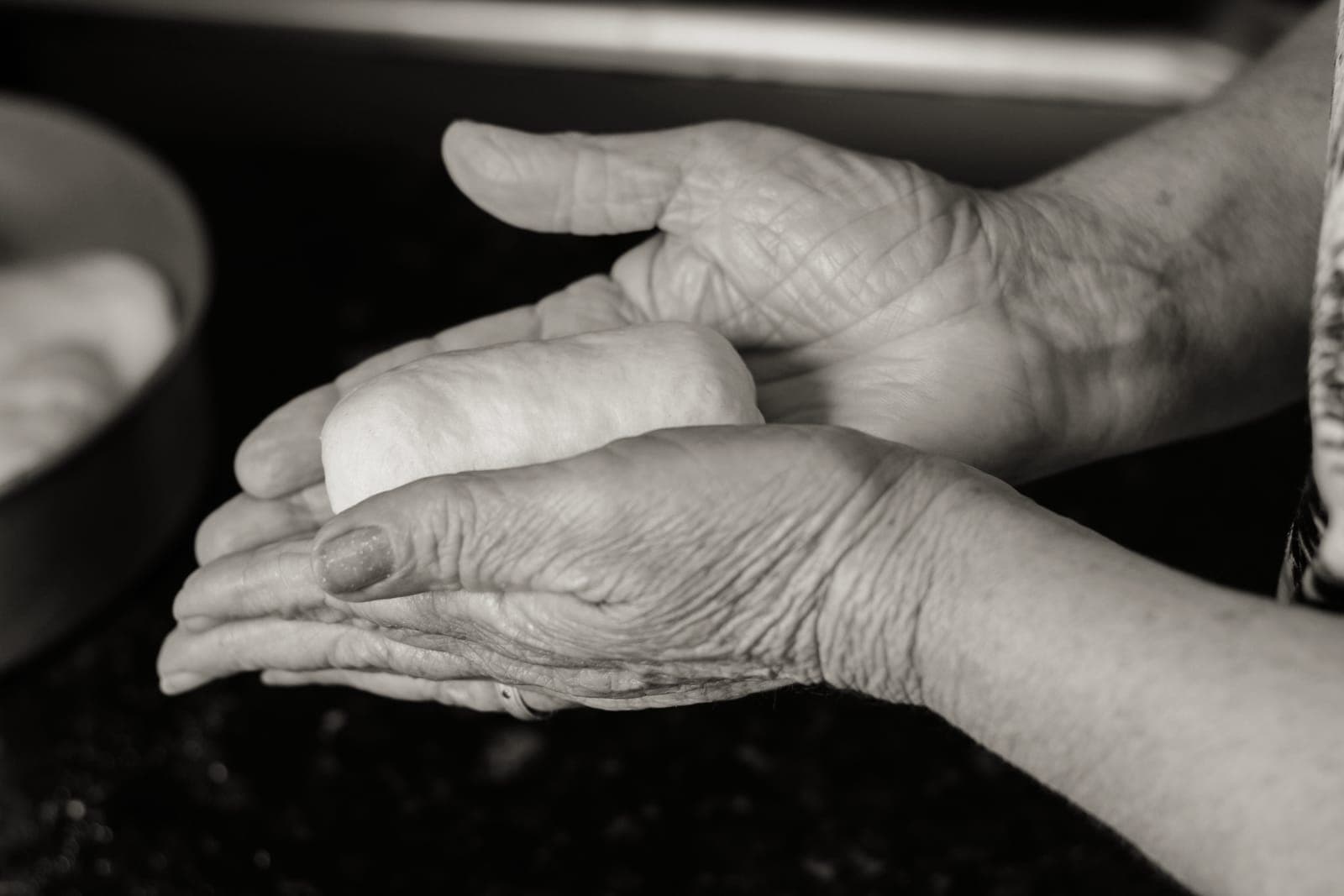 A pair of older hands preparing food in a kitchen