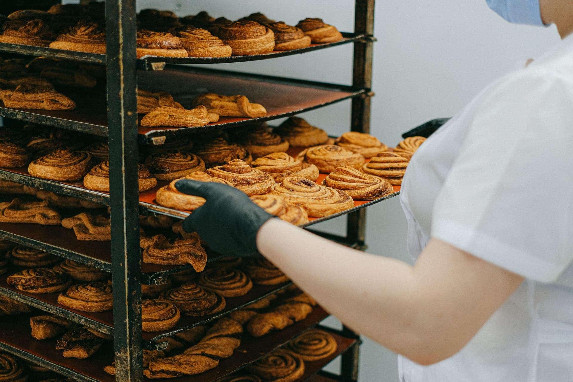 Freshly baked food being moved from an oven to a cooling rack