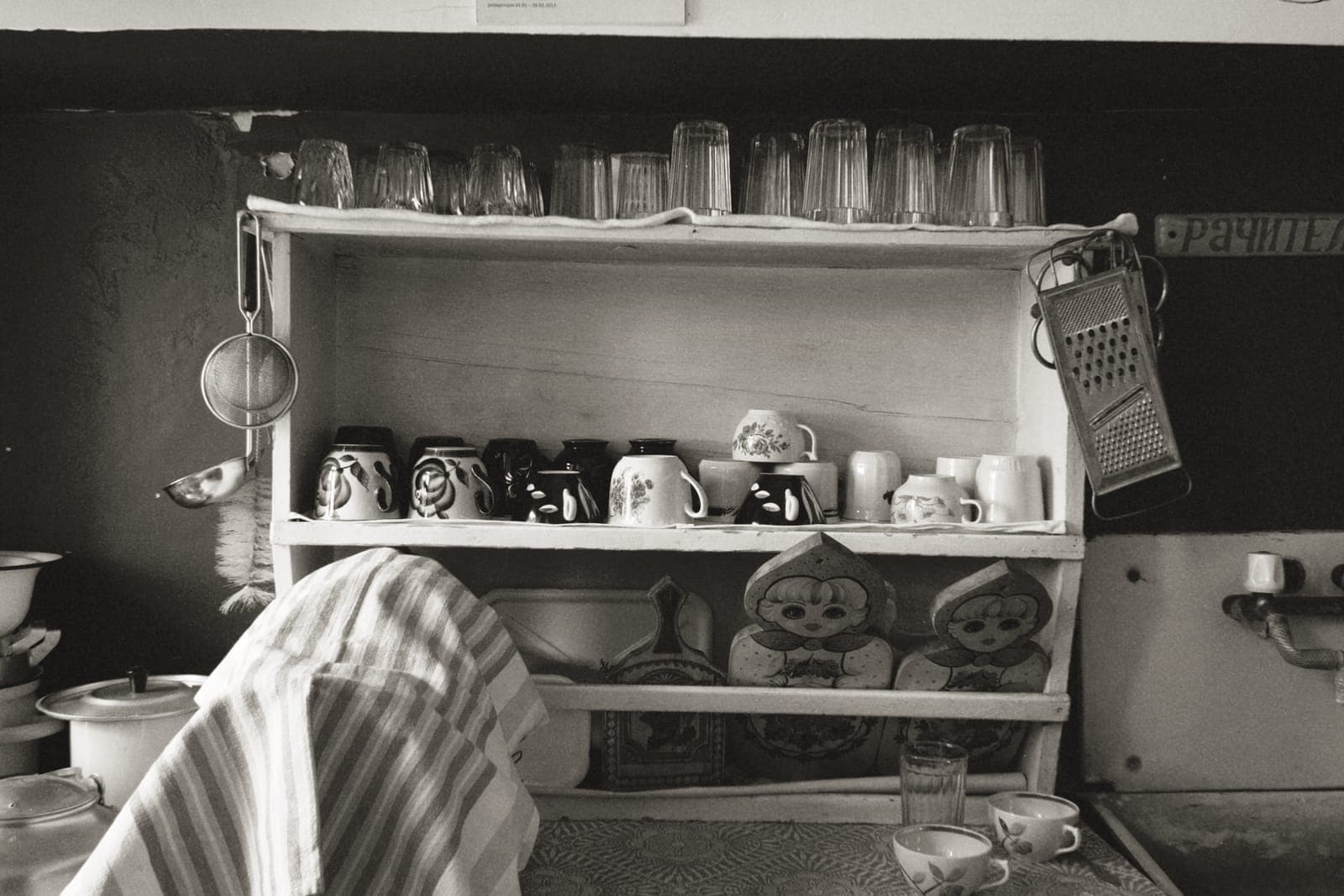 A kitchen shelf holding assorted cookware and utensils