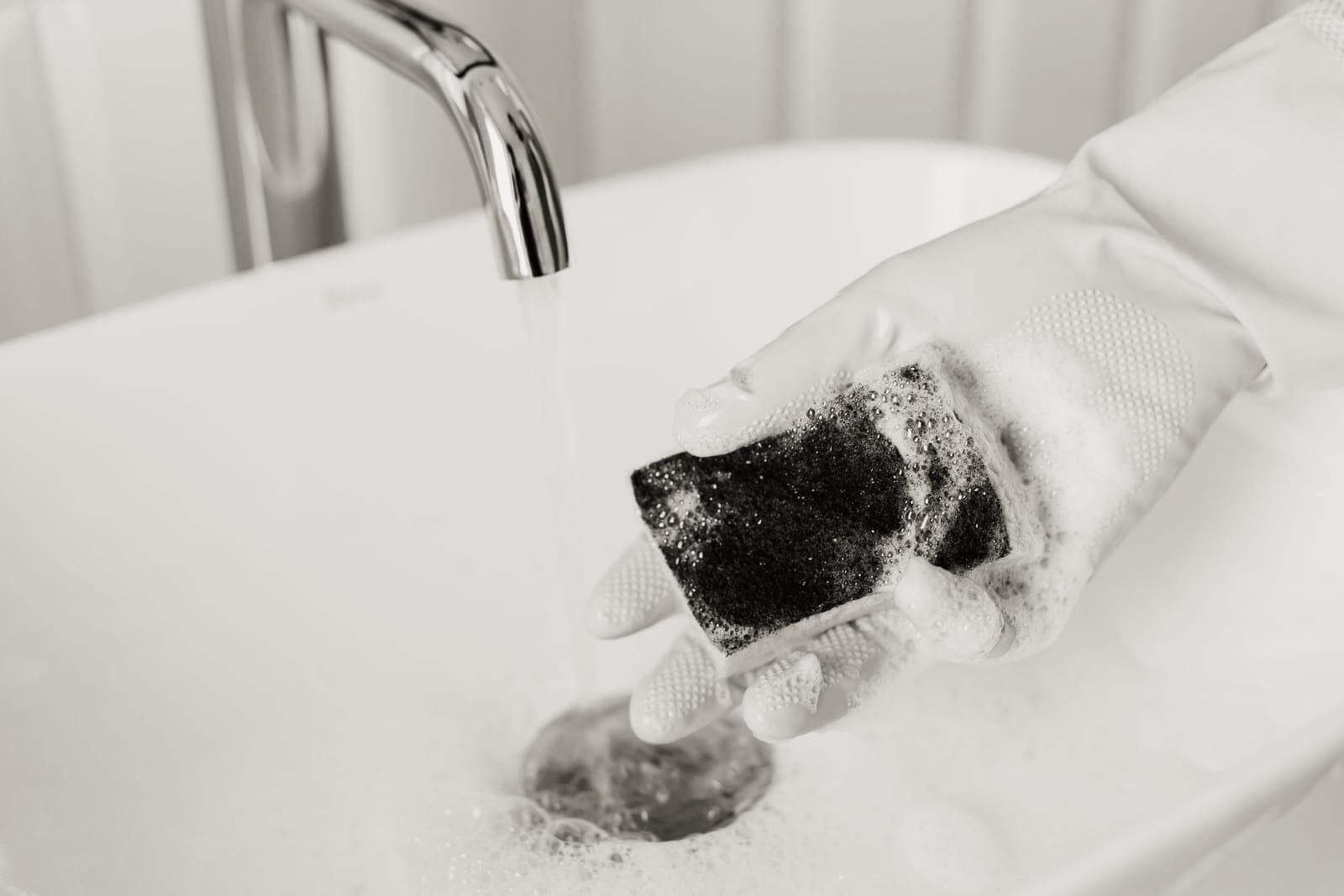 A sponge and detergent beside a kitchen sink