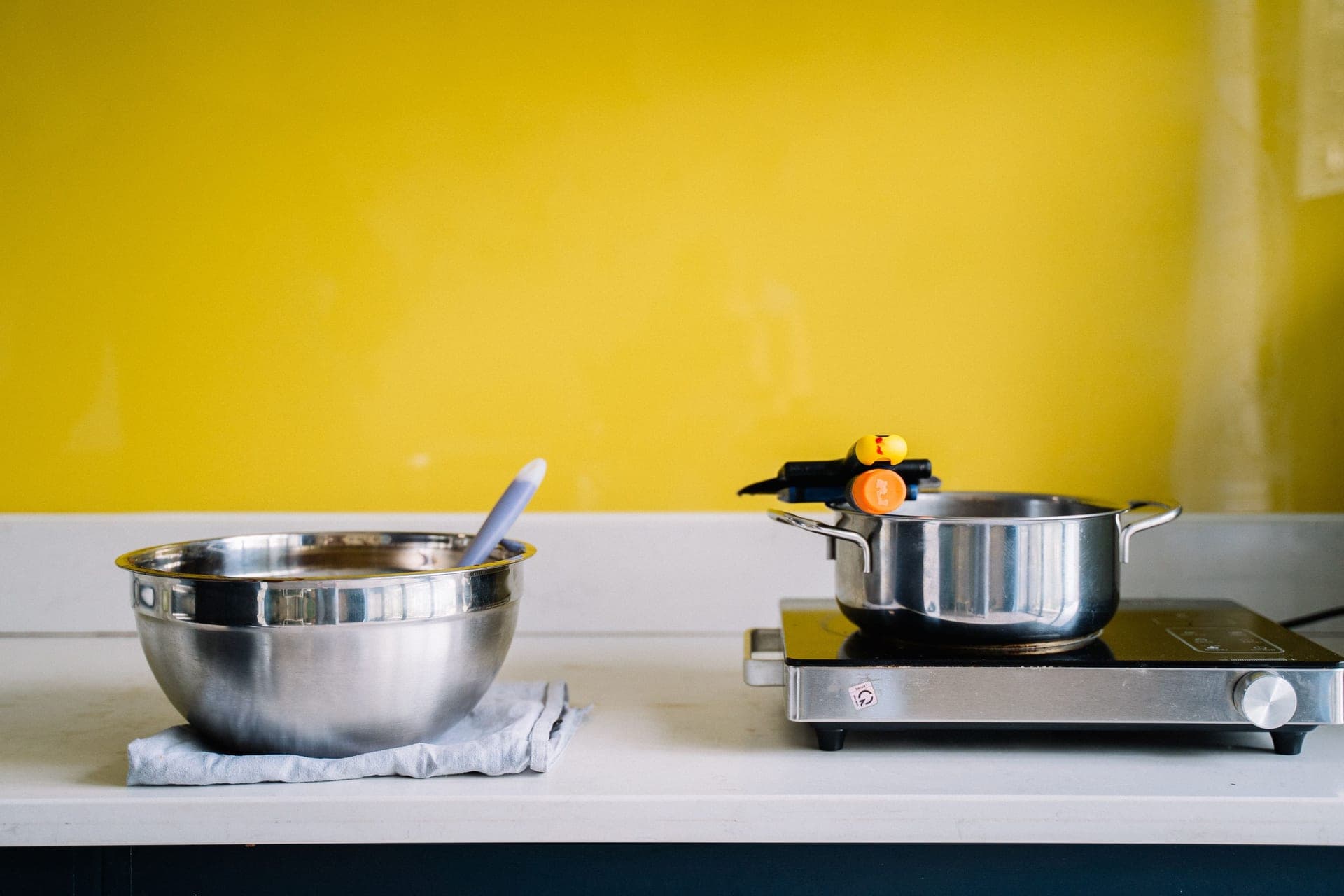 A set of stainless steel pans arranged in a kitchen