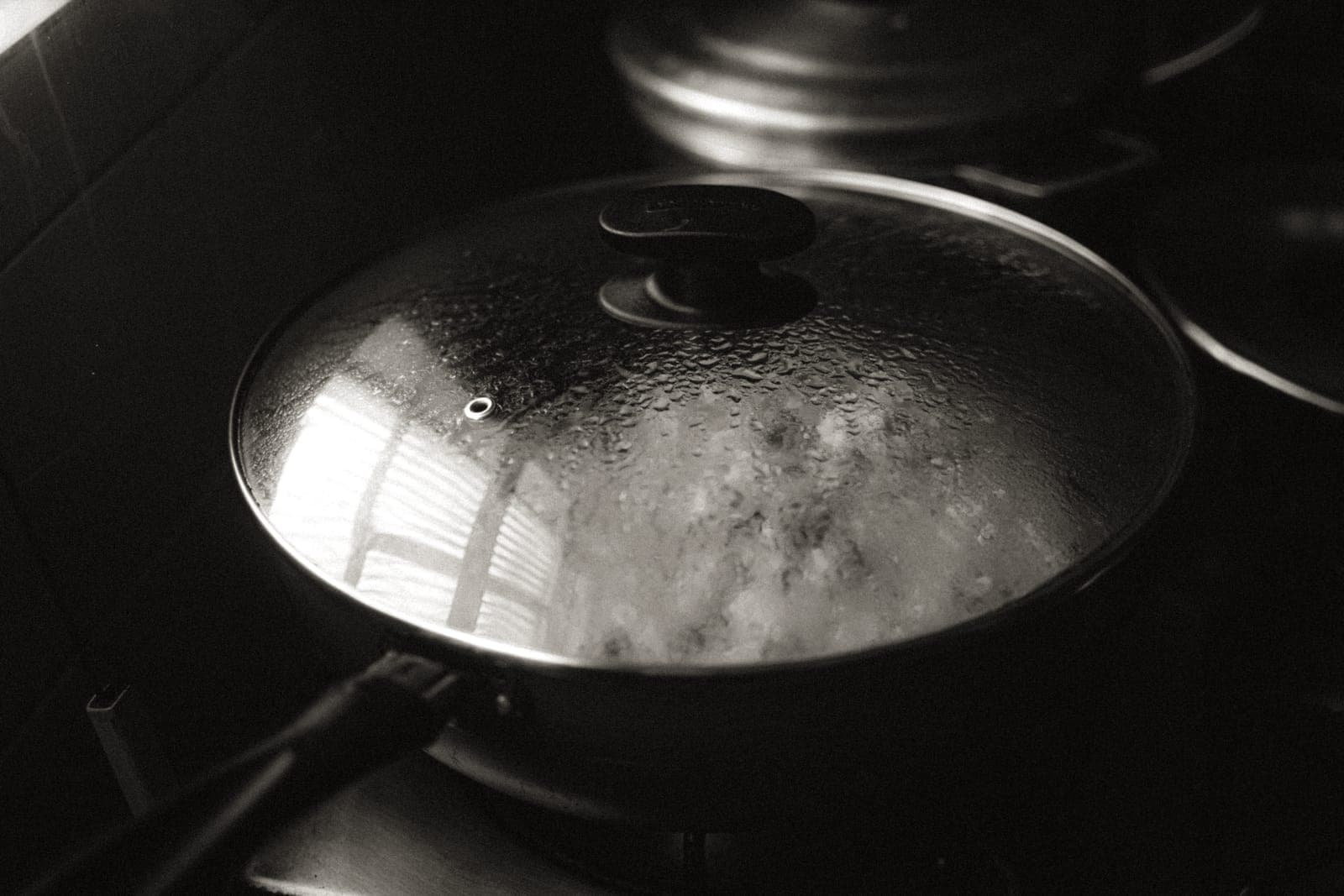A glass pot lid with steam escaping