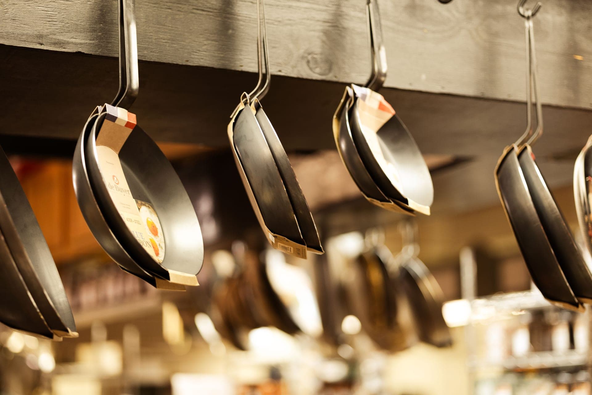 Frying pans hanging on display in a kitchenware shop