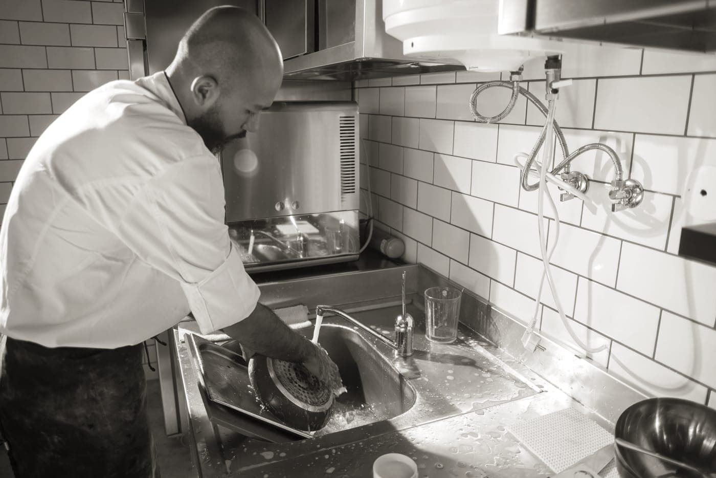Scrubbing a stainless steel pan in a kitchen sink