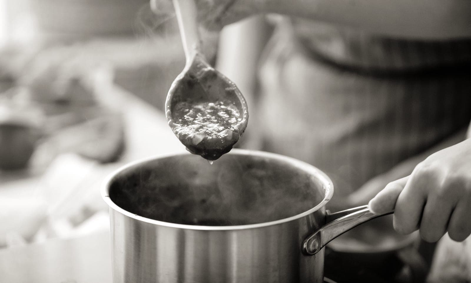 A saucepan of sauce simmering on a stove